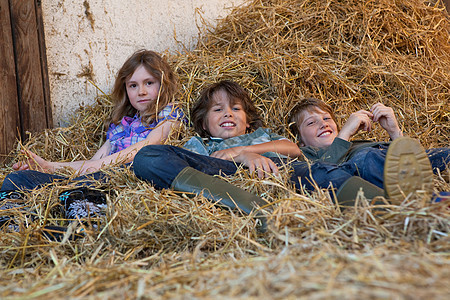 三个孩子在干草里休息图片