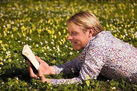 春天趴在草丛中读书的人图片