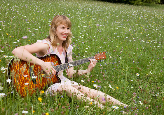 在草地上弹吉他的女人图片