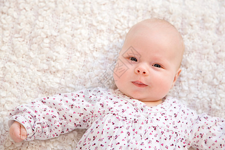 躺在白色毯子上微笑的婴儿背景图片