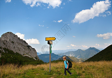 徒步山男孩在草地上徒步旅行背景