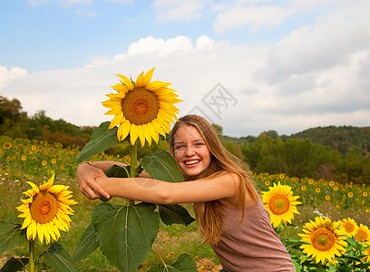 在田里拥抱向日葵的少女图片