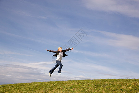 在草地上跳跃的人图片
