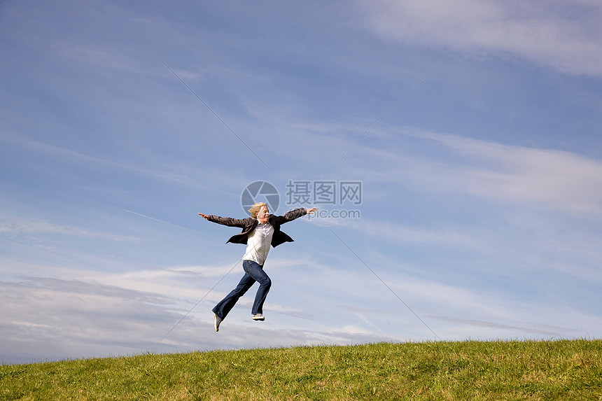 在草地上跳跃的人图片