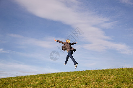 在草地上跳远的人图片