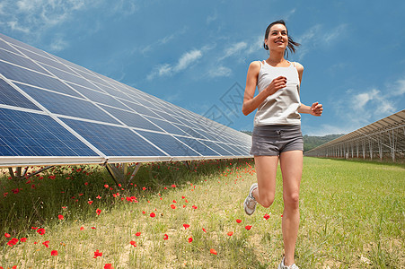 沿着太阳能电池板慢跑的女人图片