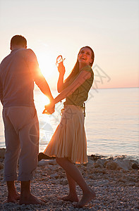 一对夫妇在海滩上欢笑图片