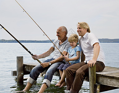 男孩和祖父父亲一起钓鱼图片
