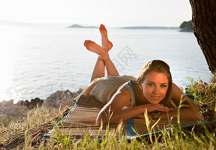 躺在长满草的海滩上的女人图片