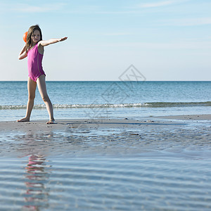 在海滩上玩球的女孩图片