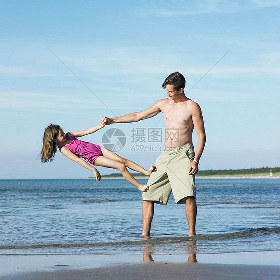 爸爸和女儿在海滩上玩耍图片