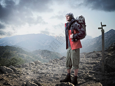 科西嘉岛站在岩石上的徒步旅行者背景