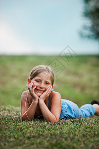 微笑的女孩躺在草地上天真高清图片素材