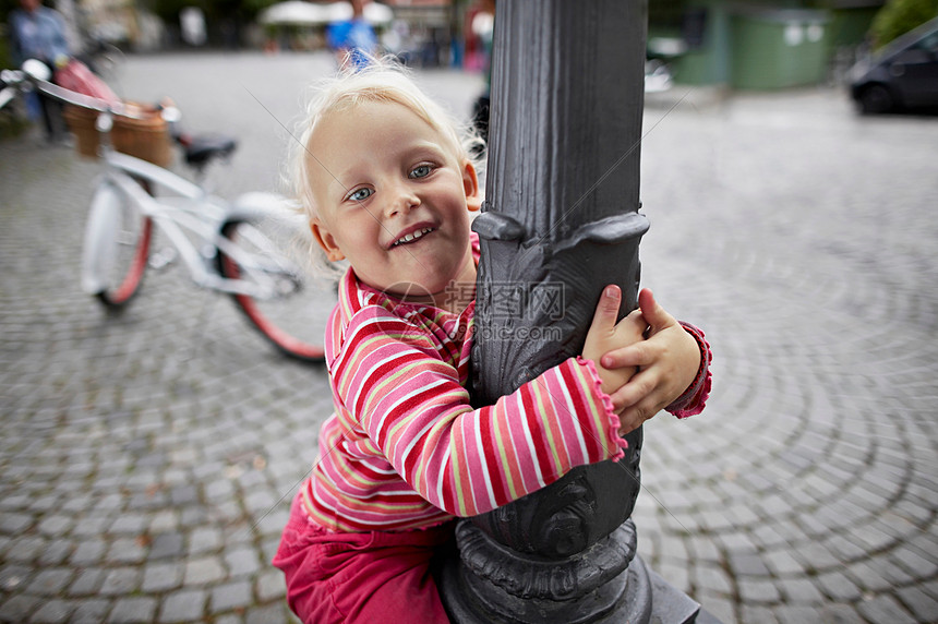 小女孩抱着灯柱图片