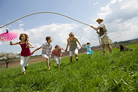 玩跳绳的孩子欢乐家庭在农村跳绳背景