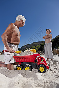 在海滩上和孙子玩的男人图片