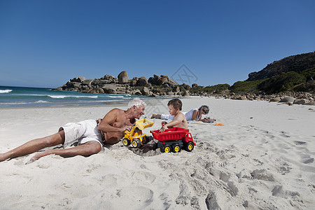 在海滩上和孙子玩的男人图片