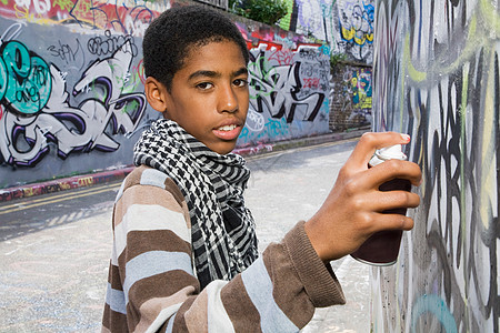 在墙上涂鸦的黑人少年背景图片