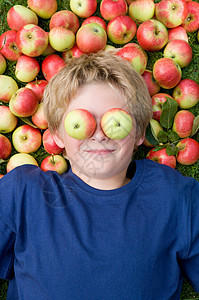 躺在苹果上眼睛上盯着苹果的男孩图片