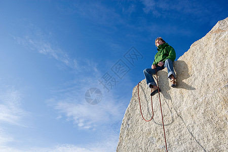 坐在山顶上的登山者图片