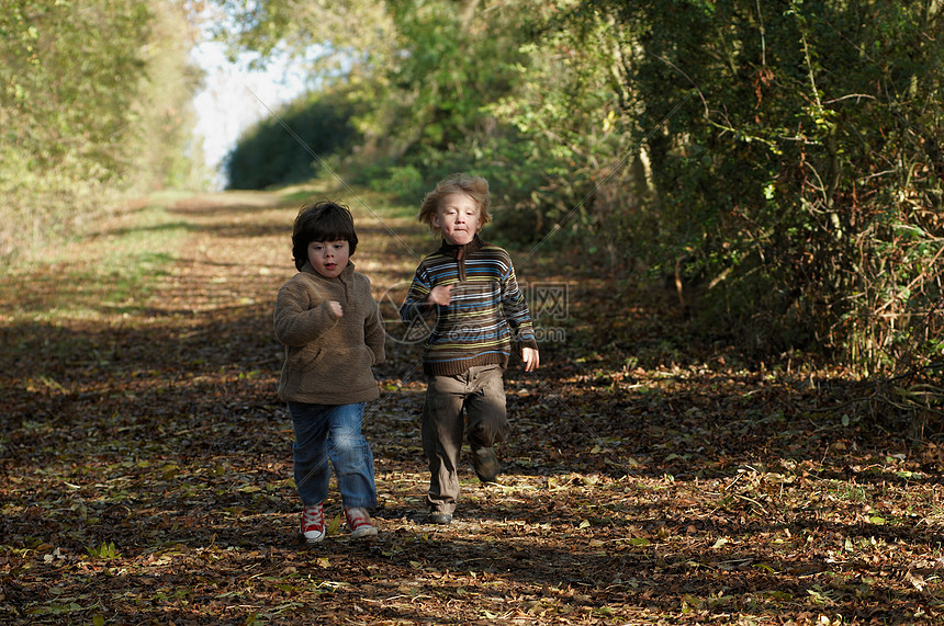 两个男孩在乡间小路上赛跑图片