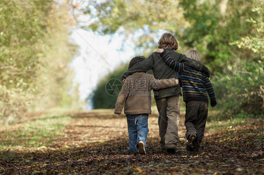 三个男孩走在乡间小路上图片