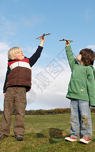 在野外玩玩具飞机的男孩图片
