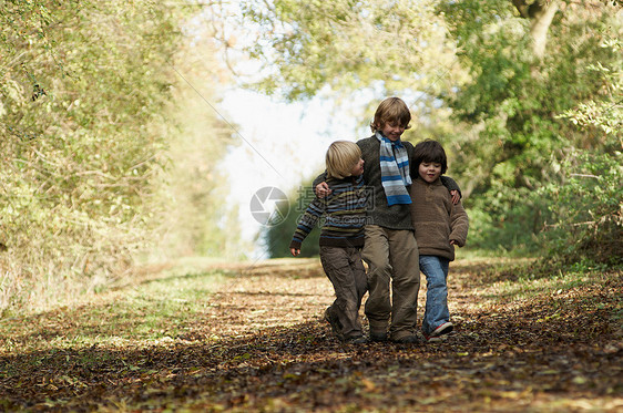三个男孩走在乡间小路上图片