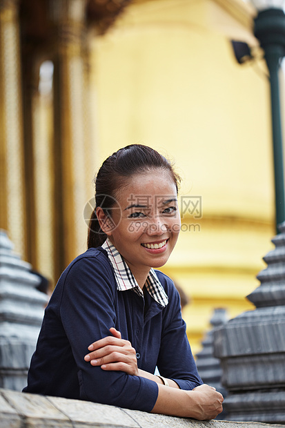 微笑的女人倚在阳台上图片