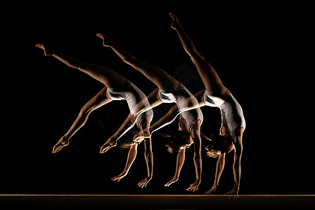 体操运动员在横梁上的多重图像高清图片