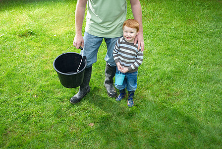 父亲和儿子在后院提着水桶图片