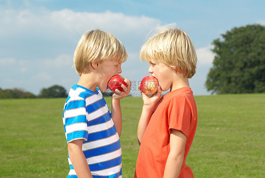 两个男孩在吃苹果图片