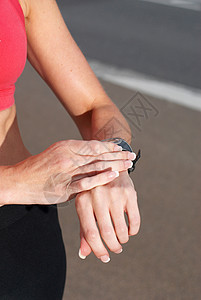跑步者检查她的手表图片