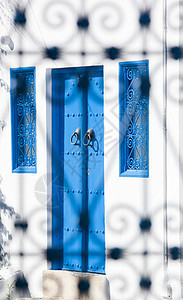 突尼斯西迪布塞的门窗上看对面的蓝白建筑图片