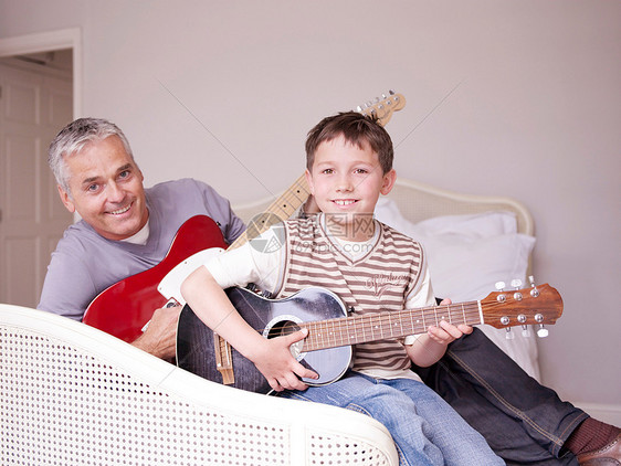 爸爸和儿子在床上弹吉他图片