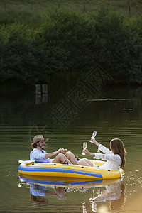 在乡村湖边的小船上的一对夫妇图片