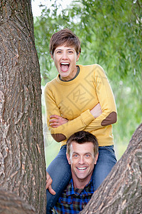 男人肩扛在树旁的女人图片