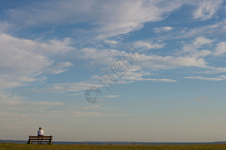 男性坐在长椅上图片