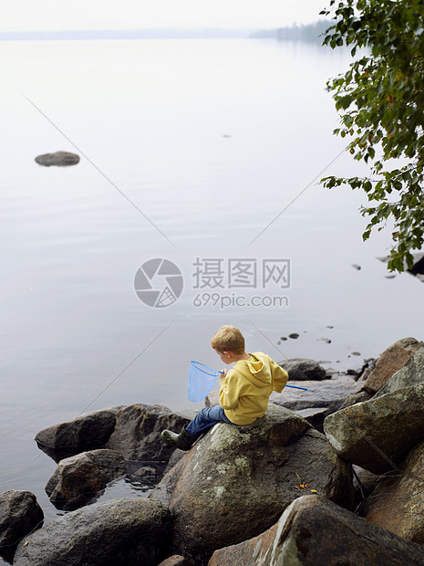 用网在湖里钓鱼的小男孩图片