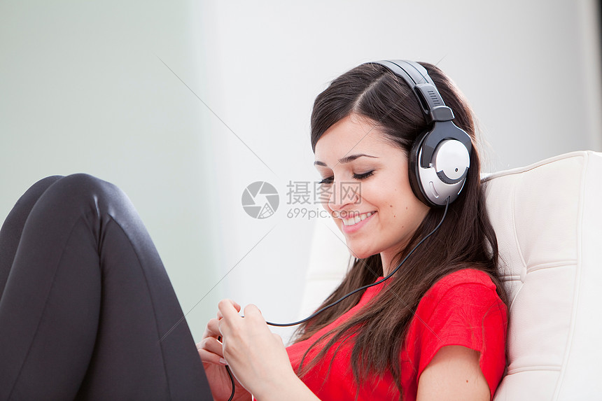 坐在沙发上听音乐的女人