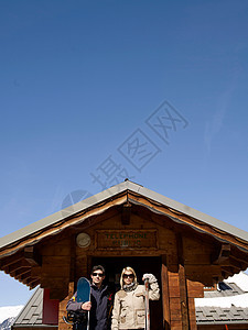 女人和男人在小屋里带着滑雪用具图片