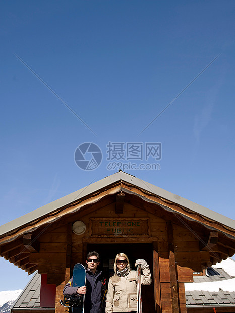 女人和男人在小屋里带着滑雪用具图片