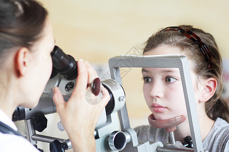 验光师检查女孩的眼睛视力图片