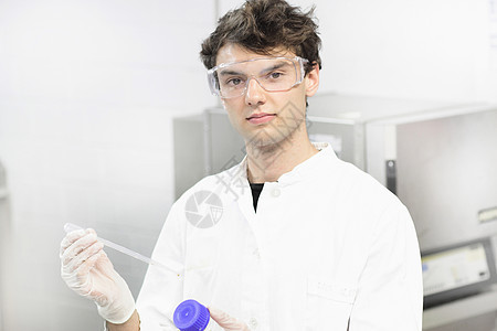 实验室里拿着滴管的科学家背景图片