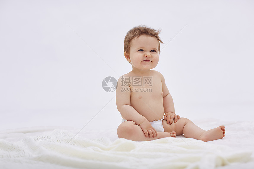 外国宝宝坐在床上微笑图片