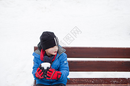 男孩在寒冷的日子里喝热饮料图片