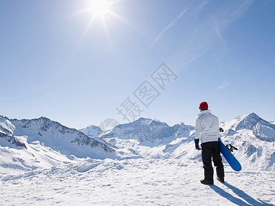 山顶上带着滑雪板的人图片