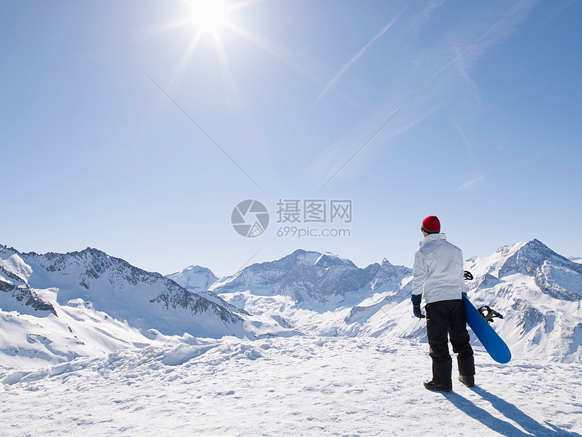 山顶上带着滑雪板的人图片