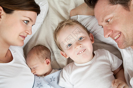 微笑的家人躺在床上图片