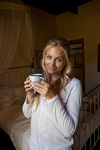 在卧室喝咖啡的女人图片